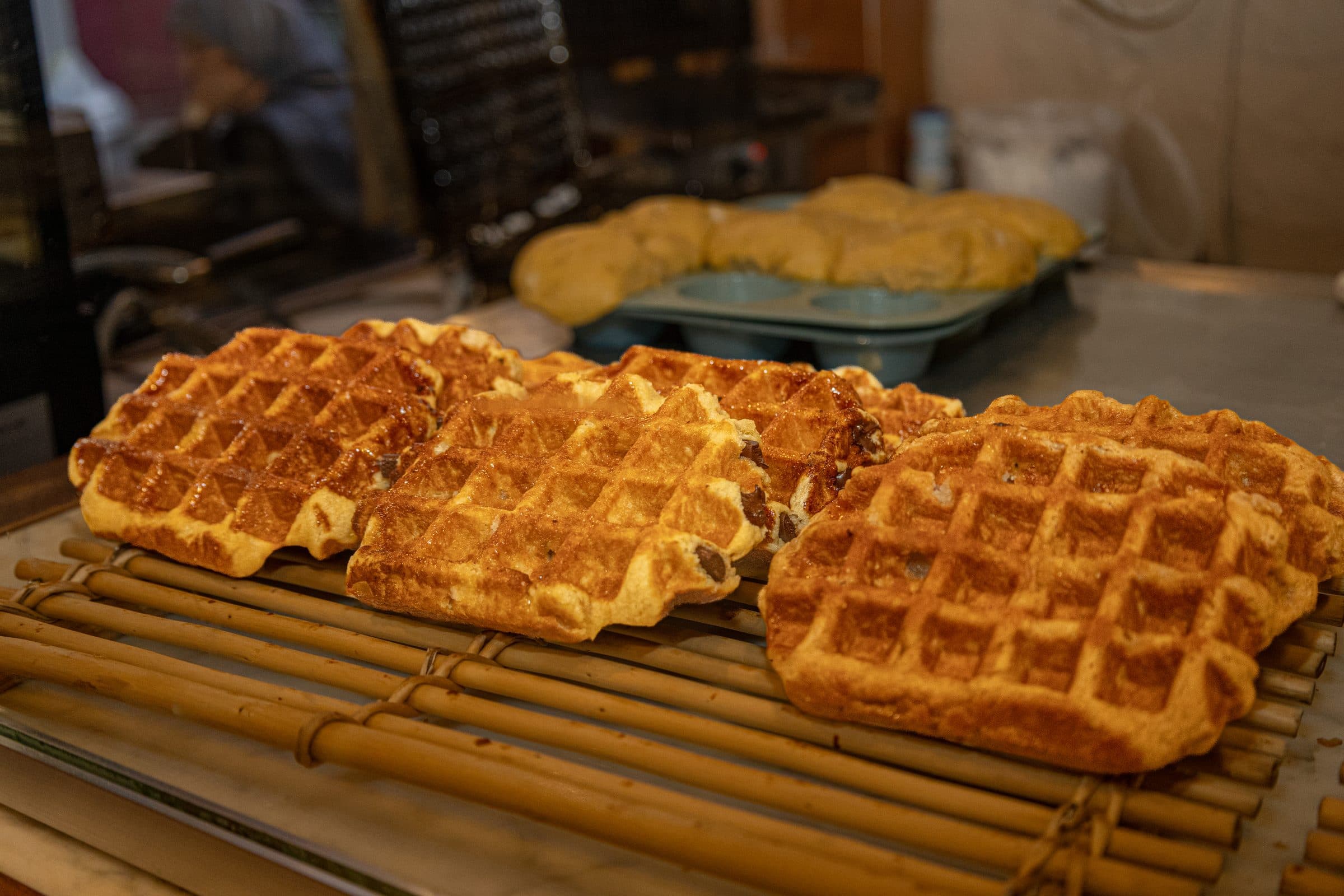 Freshly baked Liège waffles cooling on a rack at Le Roi de la Gaufre
